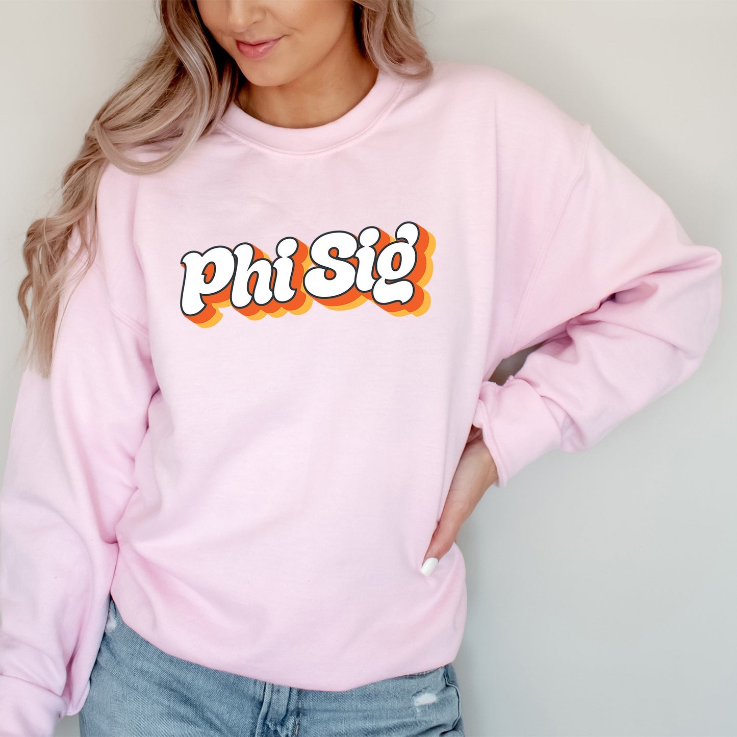 a woman wearing a pink sweatshirt that says phi sig