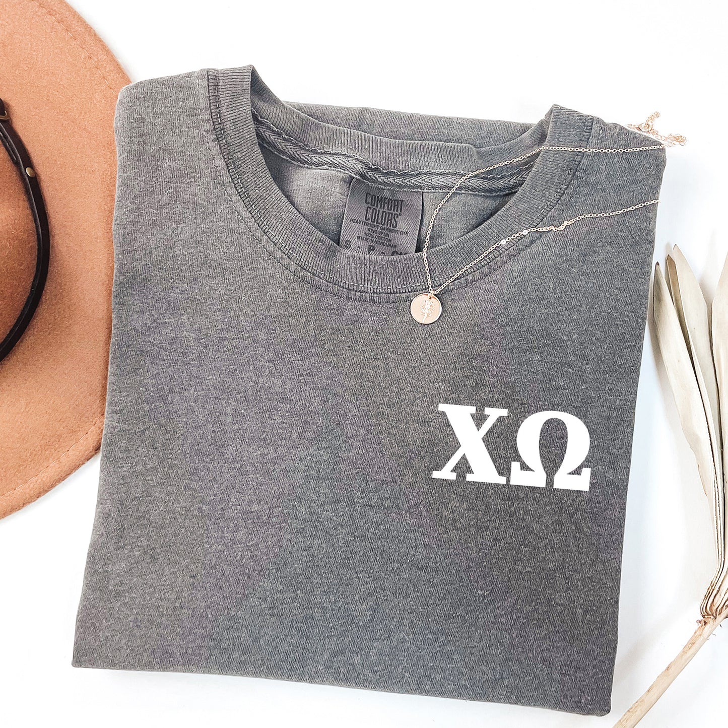 a hat, sunglasses, and t - shirt on a white surface