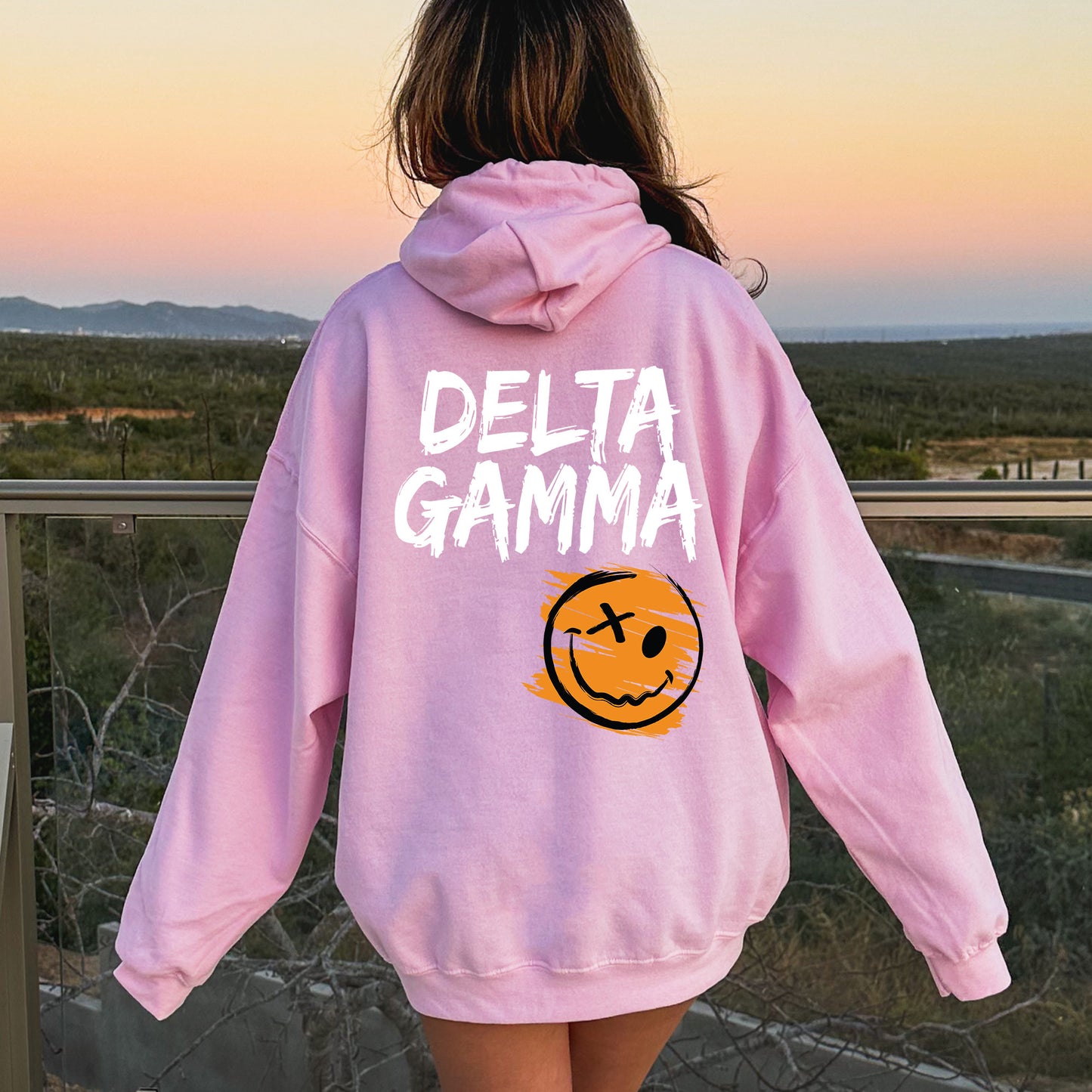 a girl wearing a pink sweatshirt with a smiley face on it