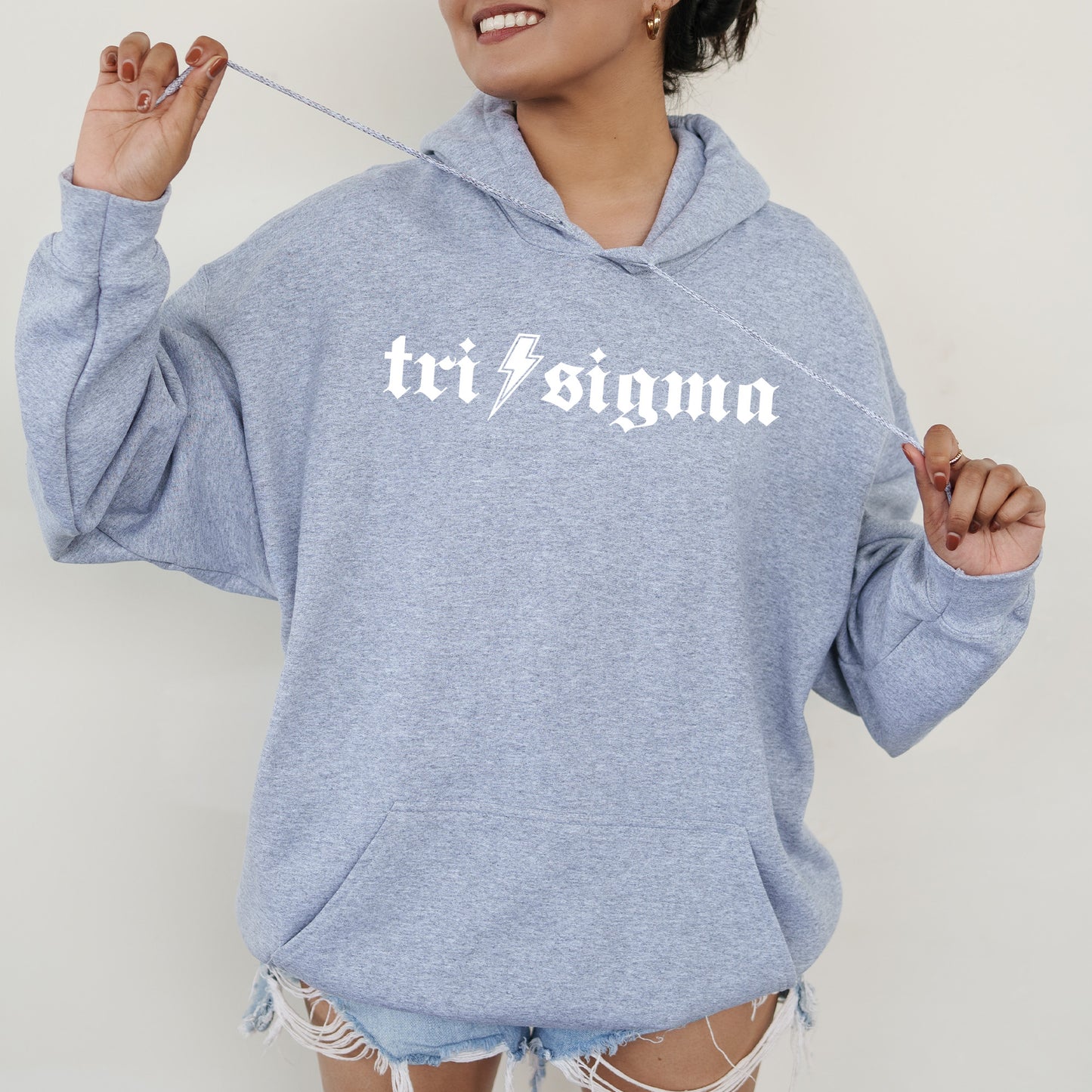 a woman wearing a blue sweatshirt with the word tri stigma printed on it