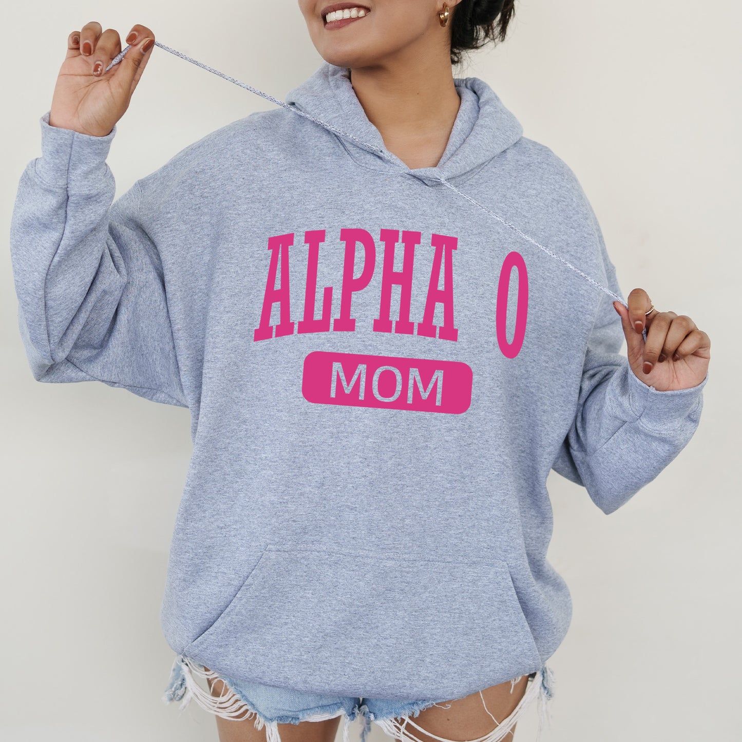 a woman wearing a blue sweatshirt with pink letters on it