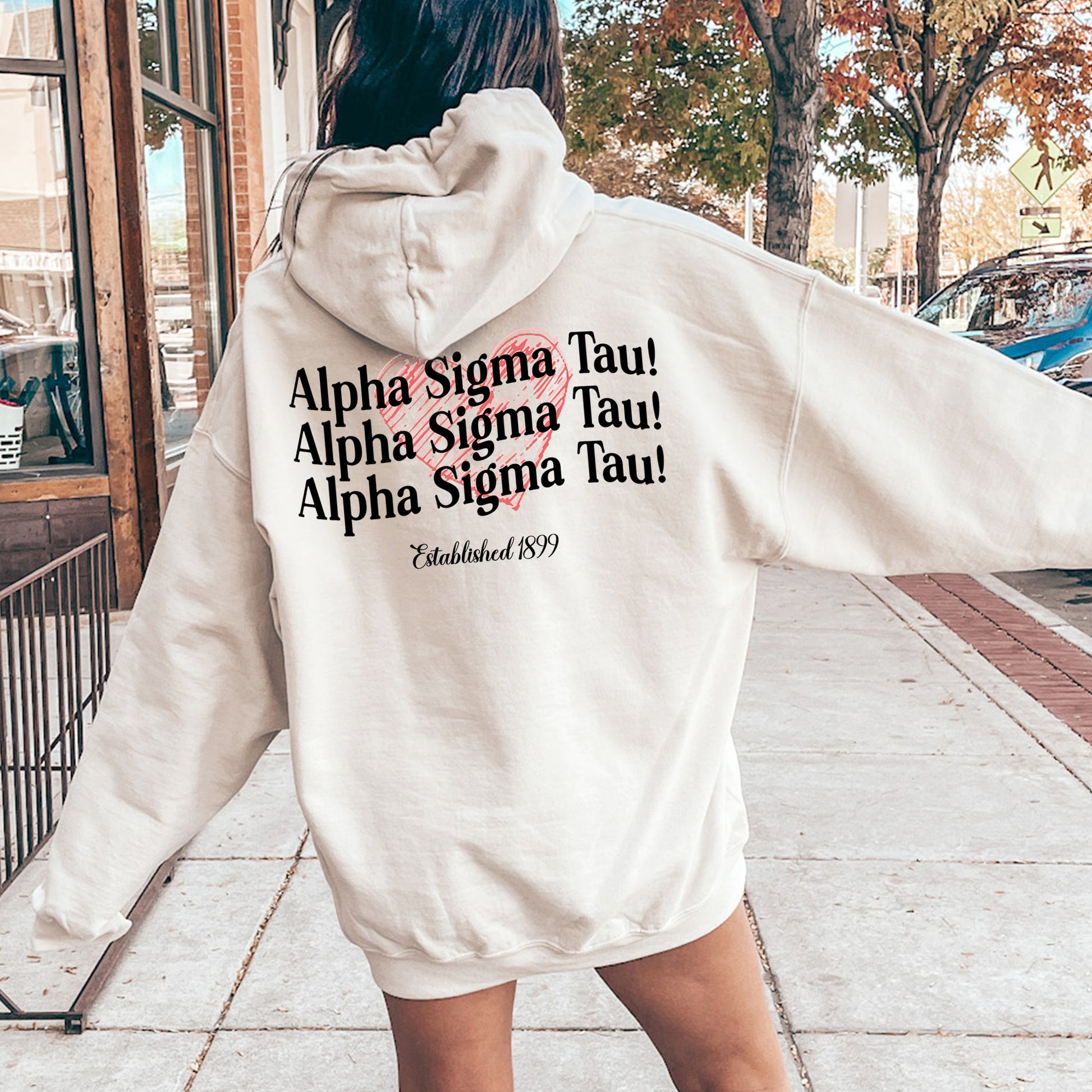 a woman in a white hoodie is walking down the street