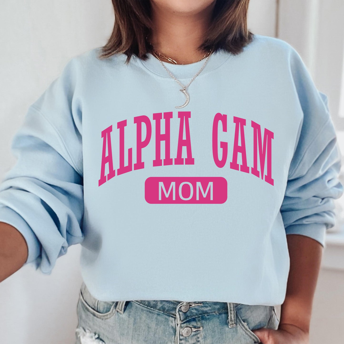 a woman wearing a blue sweatshirt that says,'alpha gam mom '