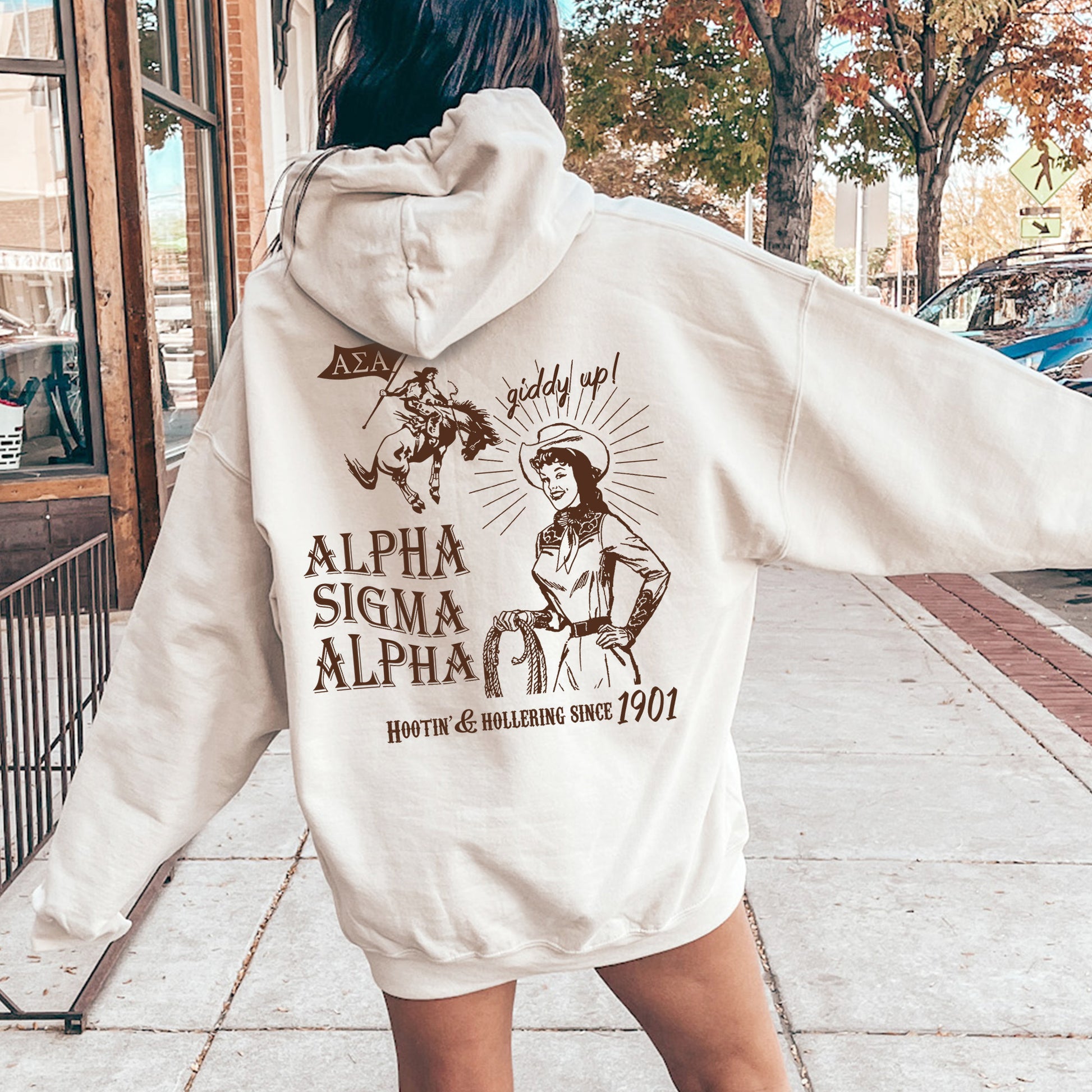a woman in a white hoodie is walking down the street