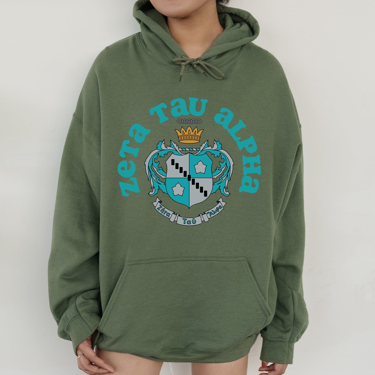 a person wearing a green hoodie with a crown on it