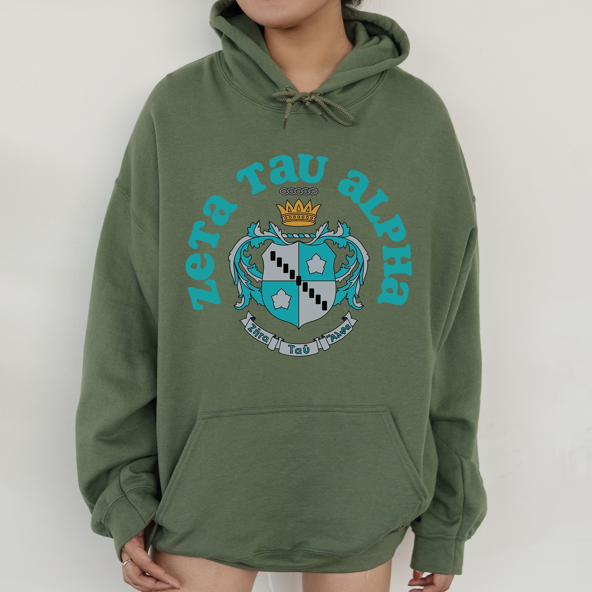 a person wearing a green hoodie with a crown on it