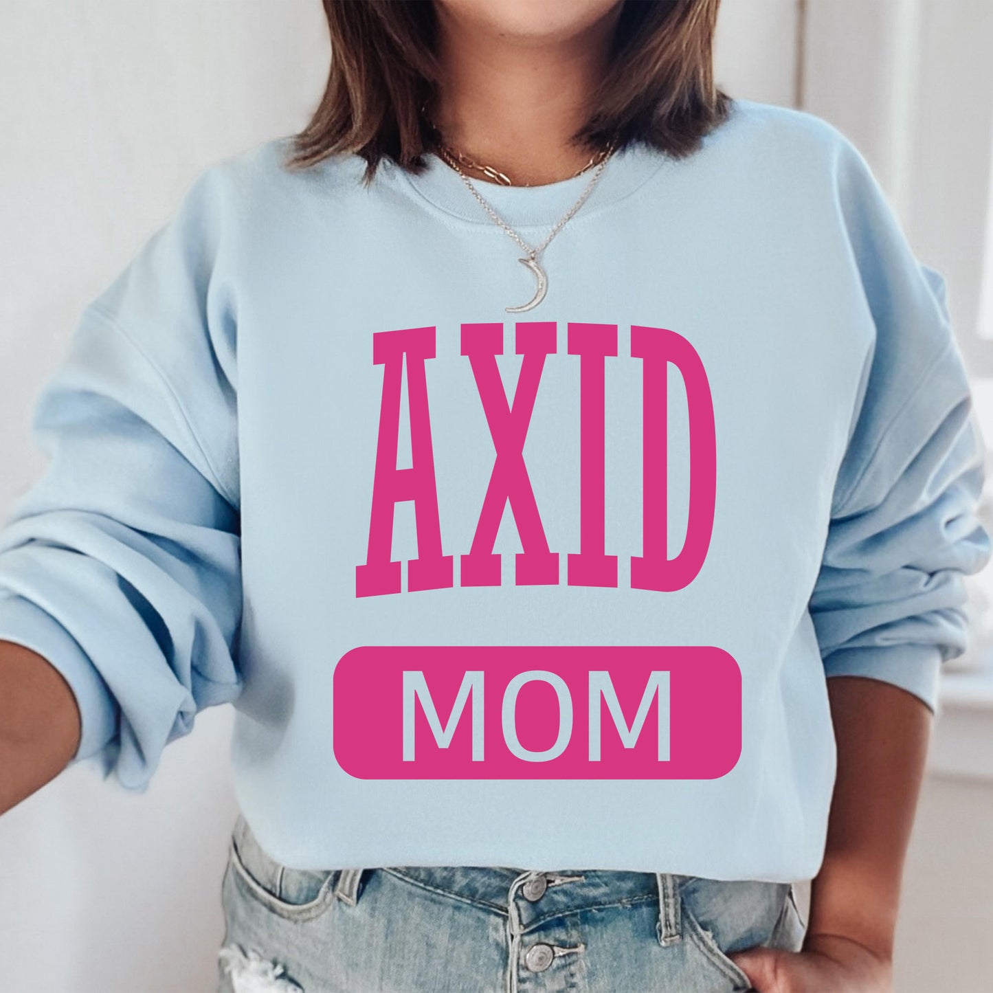 a woman wearing a sweatshirt that says axd mom