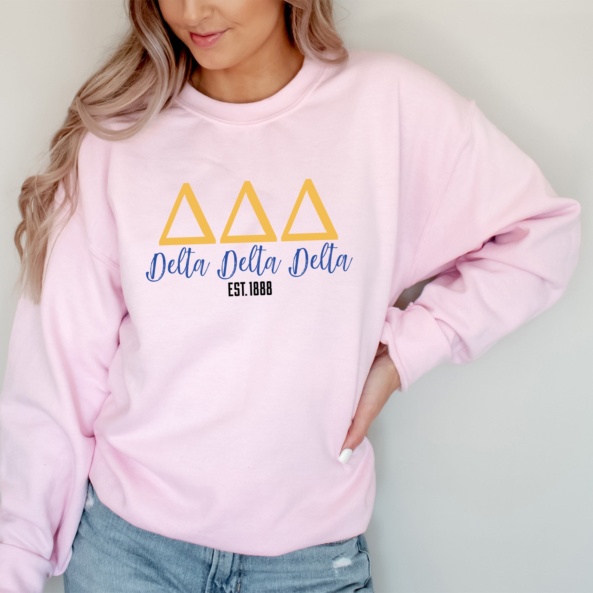 a woman wearing a pink delta delta sweatshirt