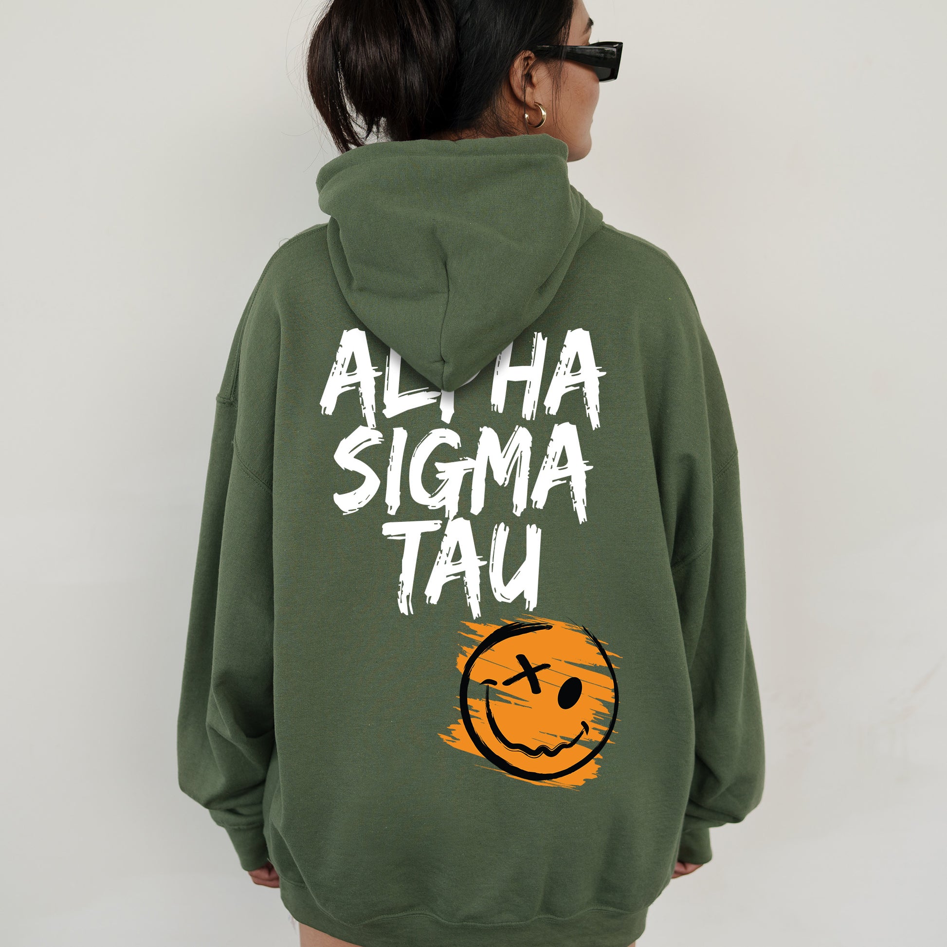 a woman wearing a green sweatshirt with a smiley face on it