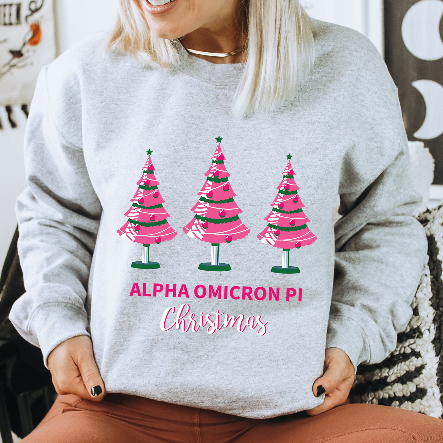 a woman wearing a sweatshirt with christmas trees on it