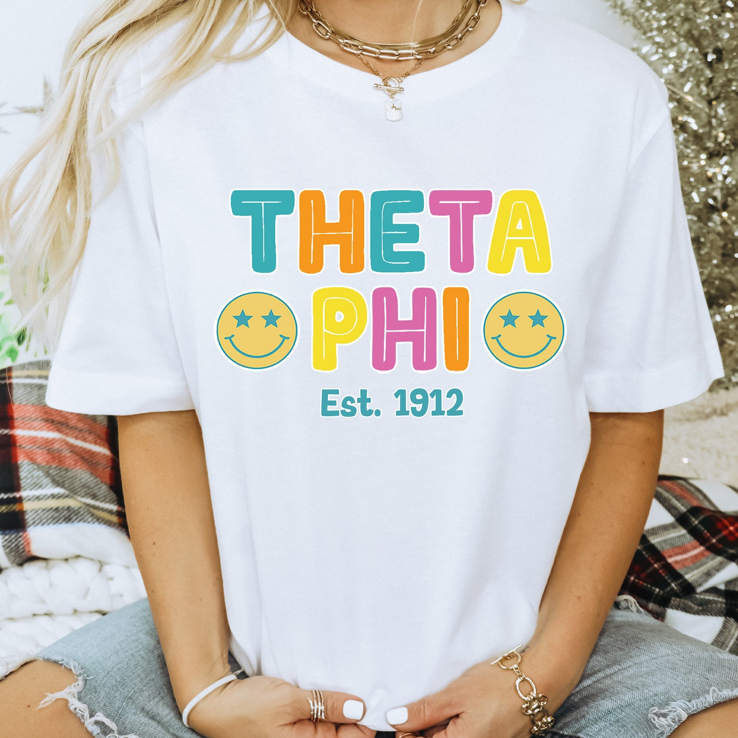 a woman wearing a white t - shirt that says thea phi est 1932