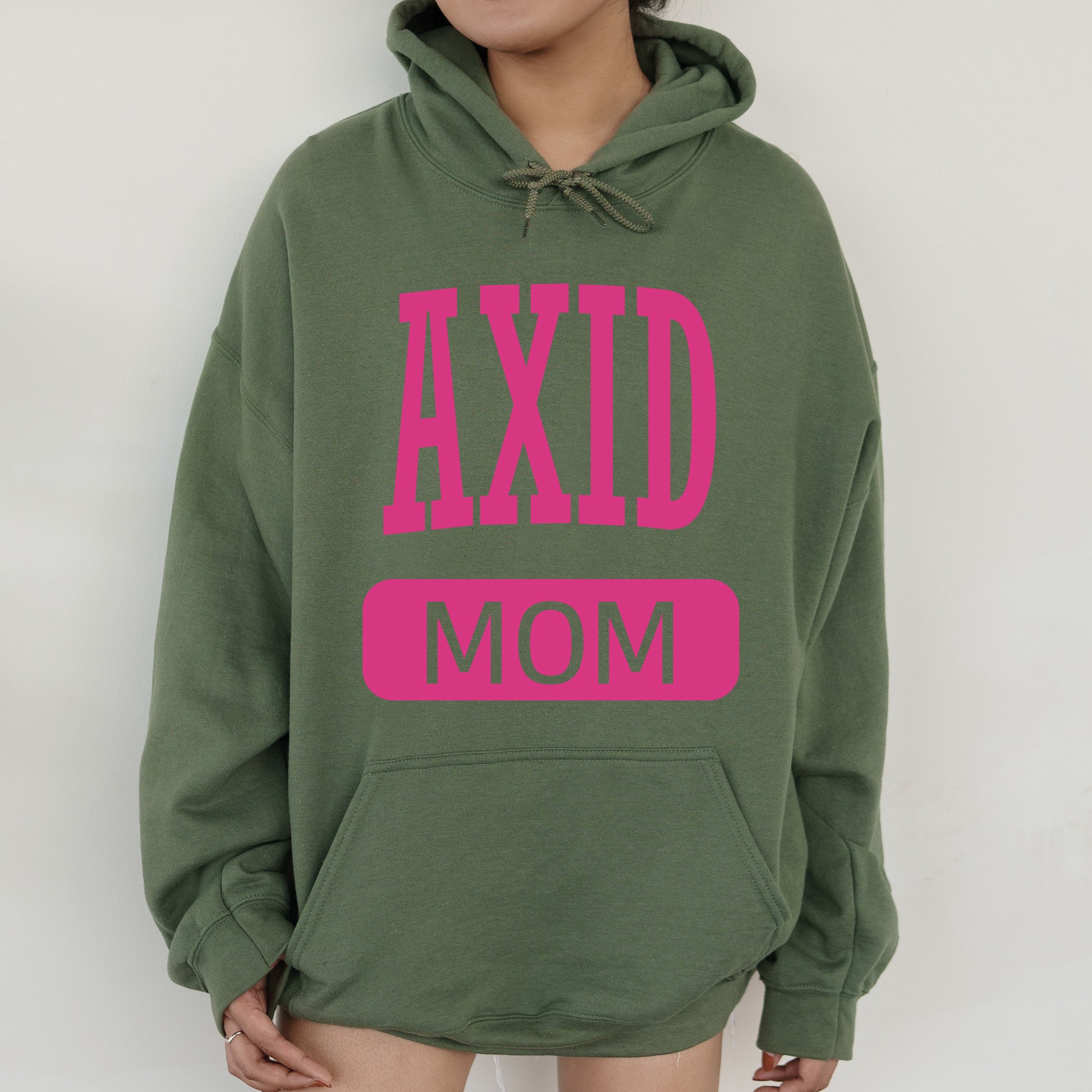 a woman wearing a green hoodie with pink letters on it