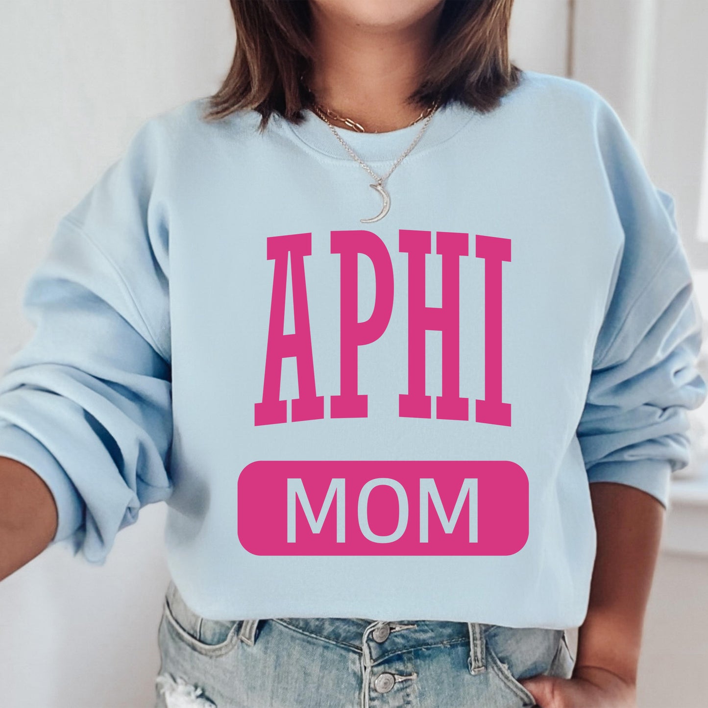 a woman wearing a blue sweatshirt with the words aphi mom printed on it
