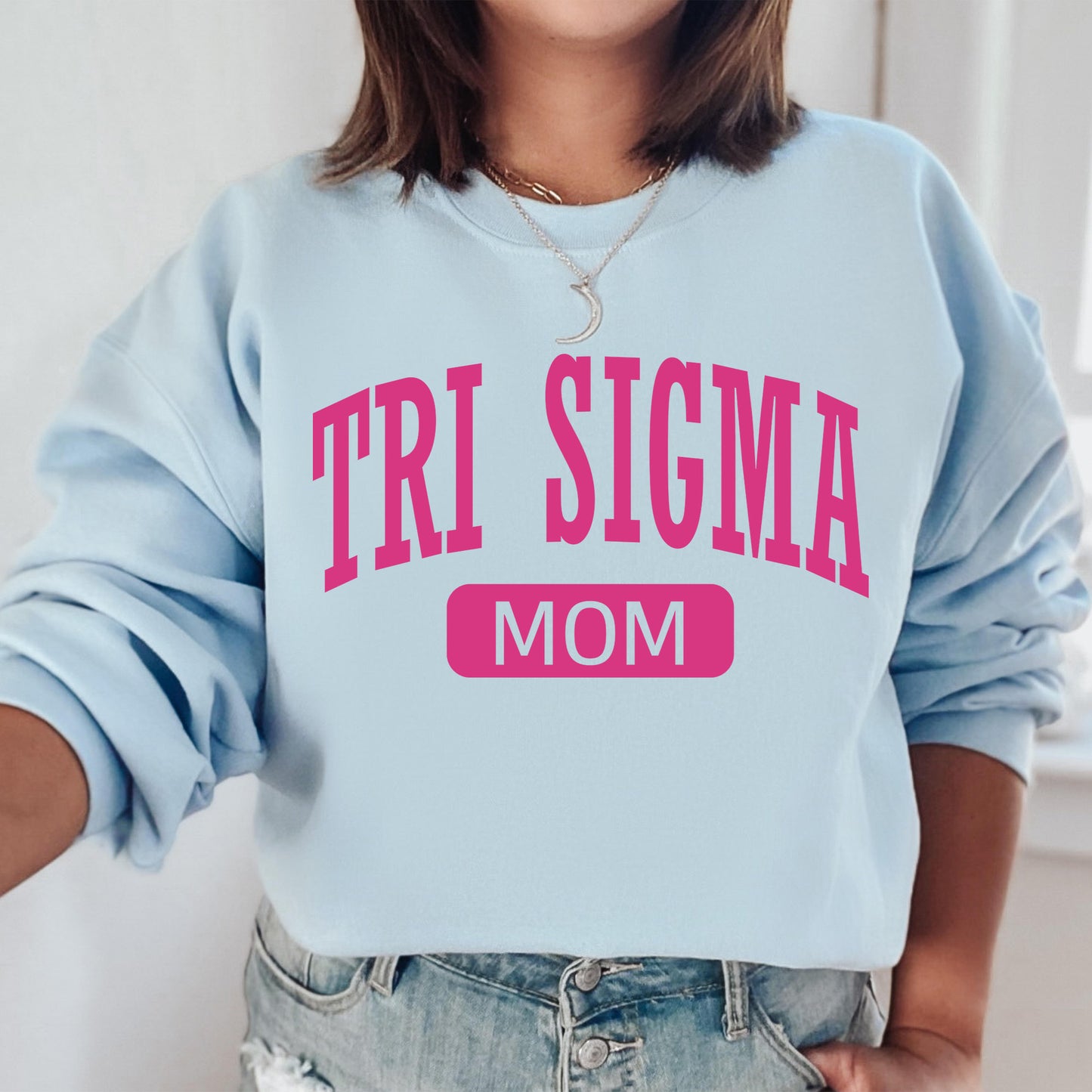 a woman wearing a sweatshirt that says tri stigma mom