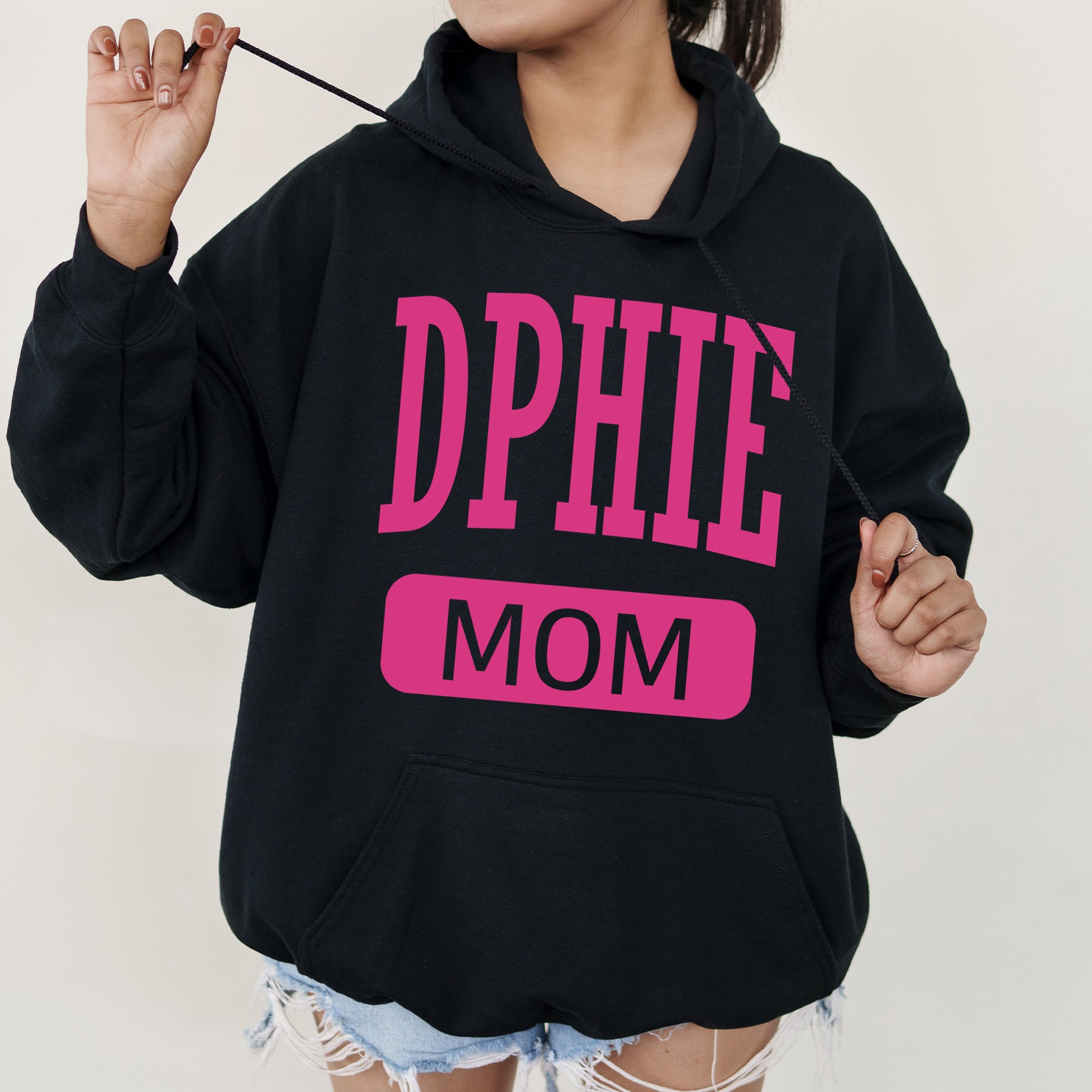 a woman wearing a black hoodie with pink letters on it