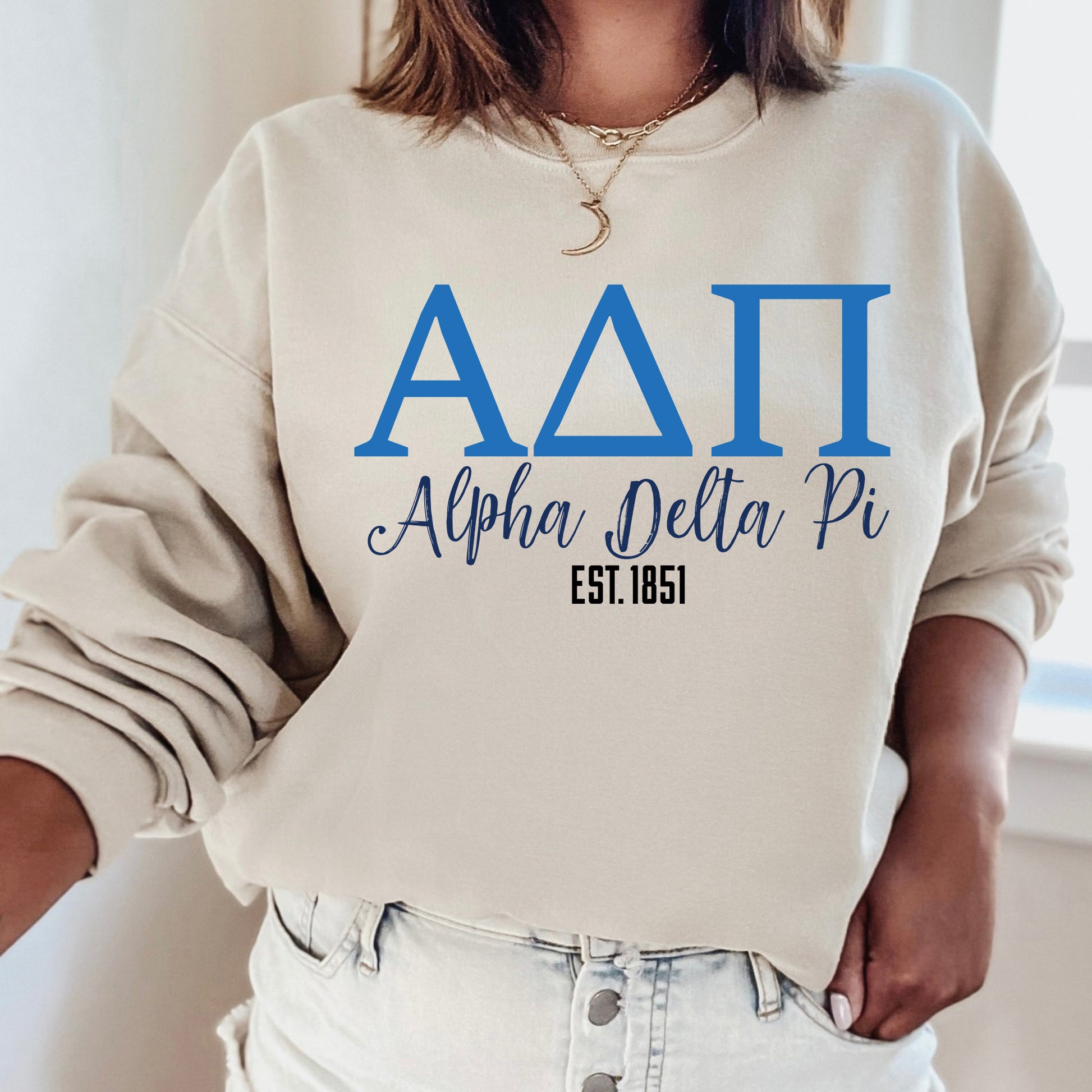 a woman wearing a sweatshirt with a delta pi on it