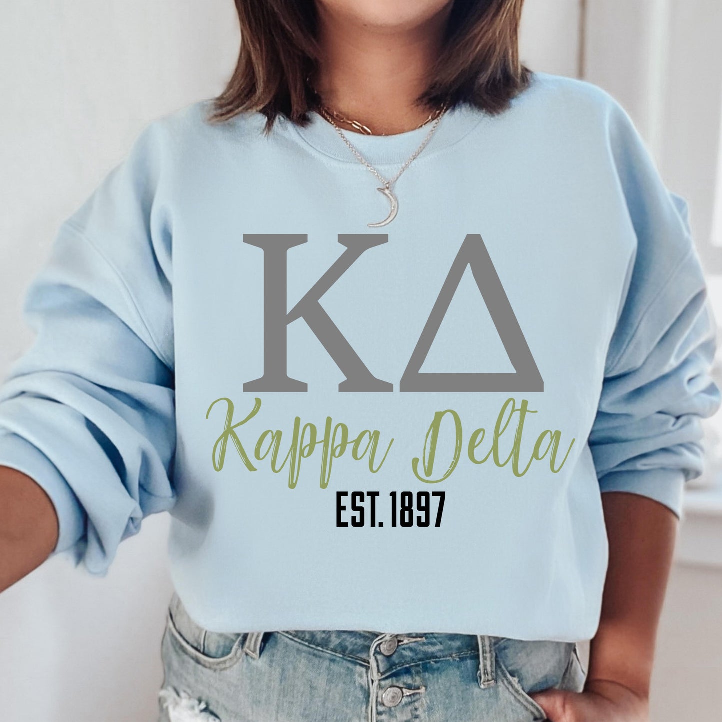 a woman wearing a blue sweatshirt with the letters kapppa delta on it