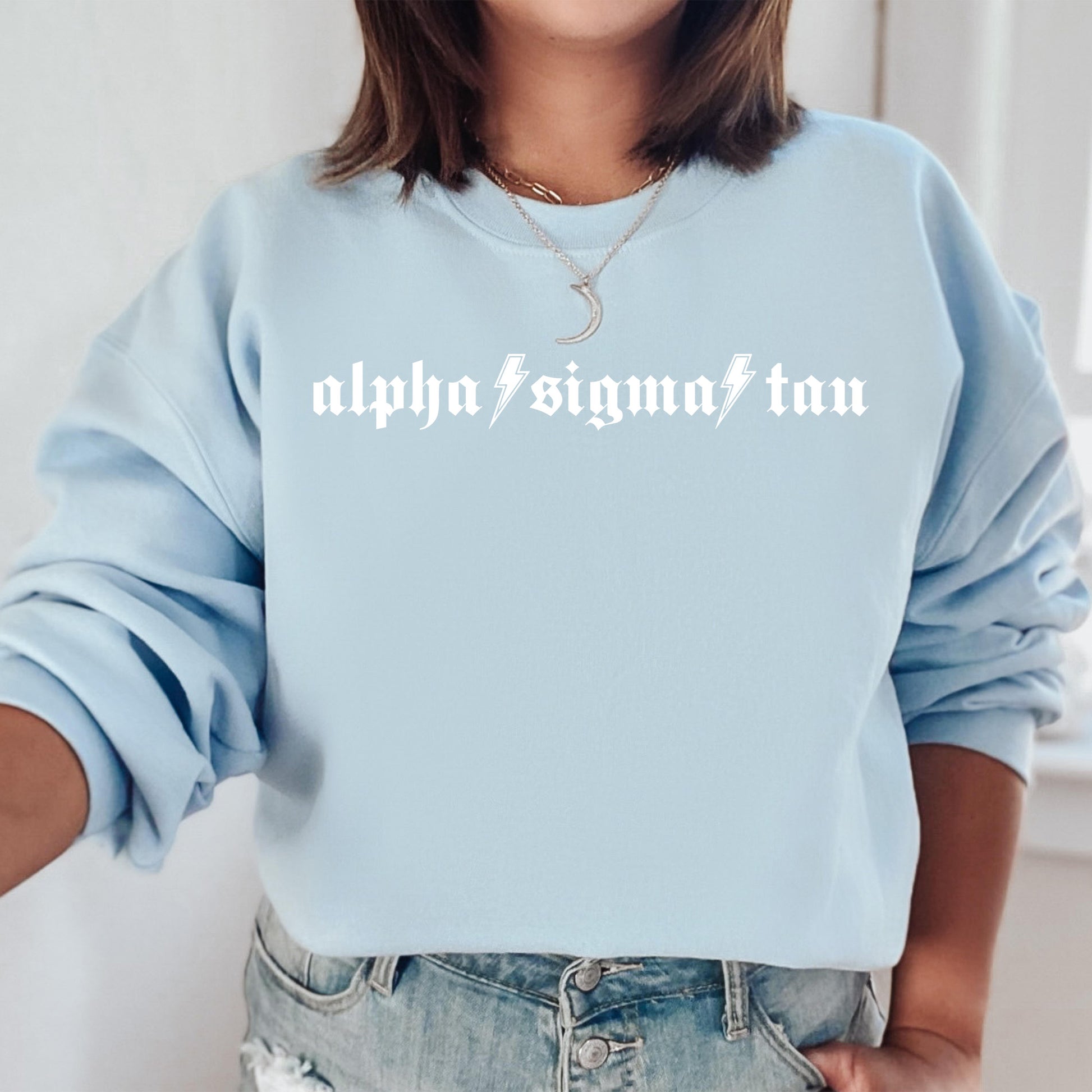 a woman wearing a light blue sweatshirt with the words alphia sigmat