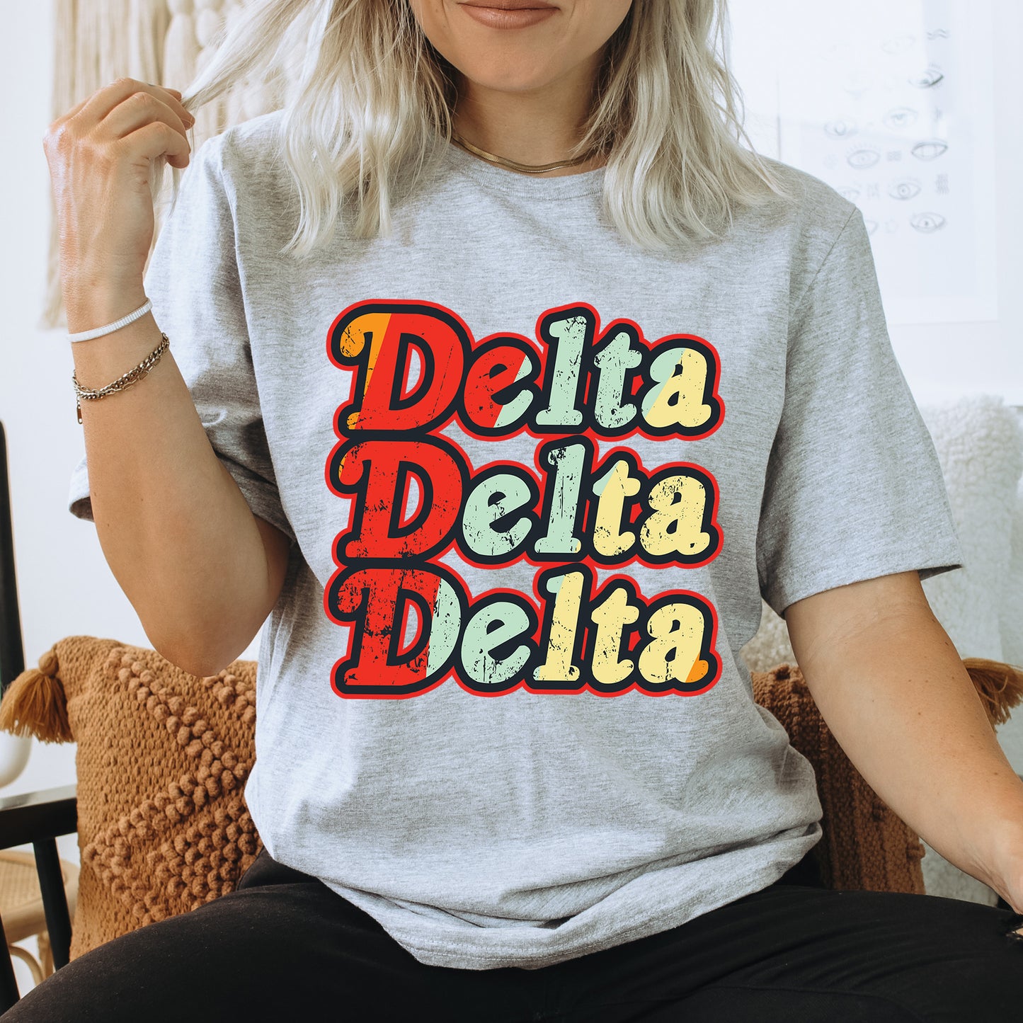 a woman sitting on a chair wearing a t - shirt that says delta delta