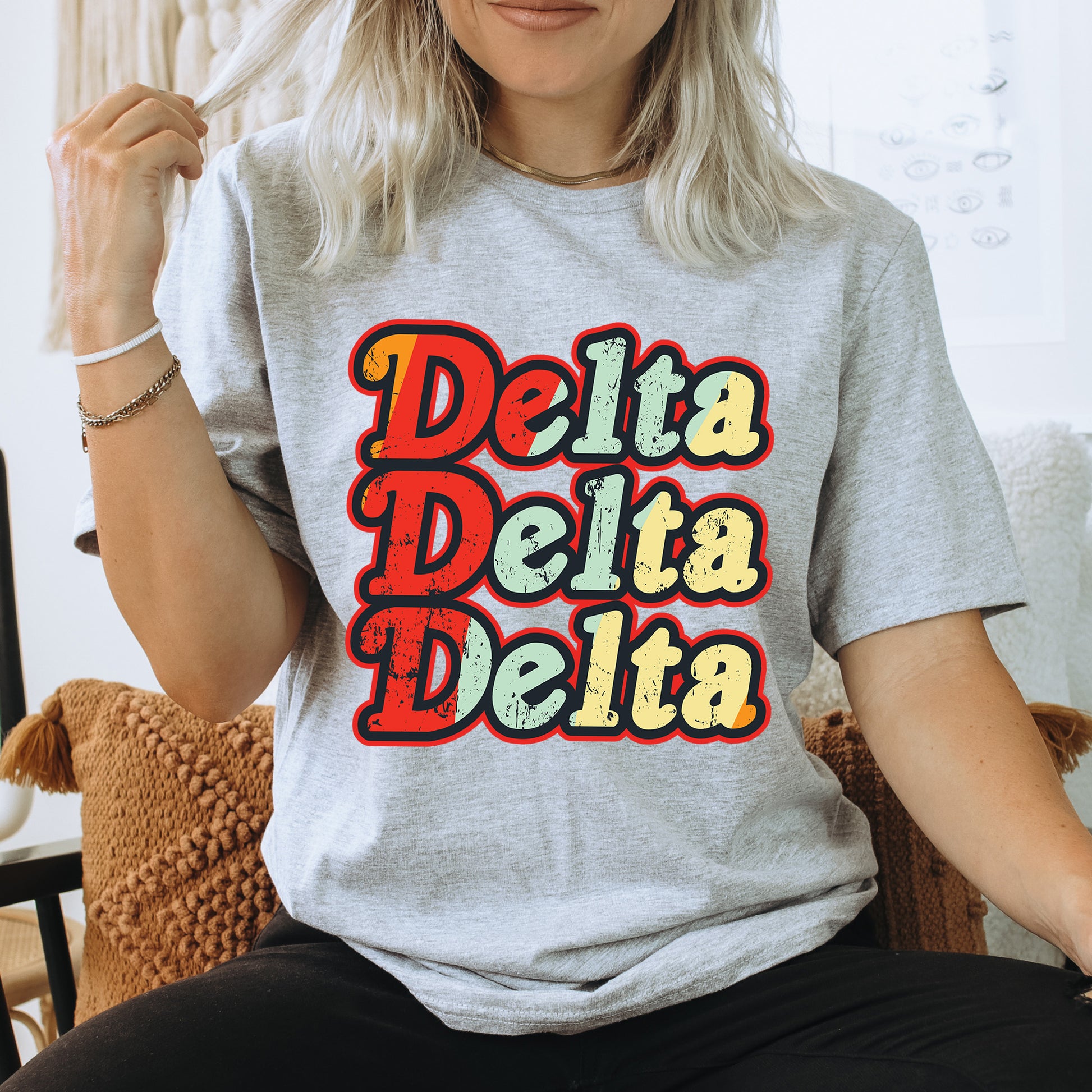 a woman sitting on a chair wearing a t - shirt that says delta delta