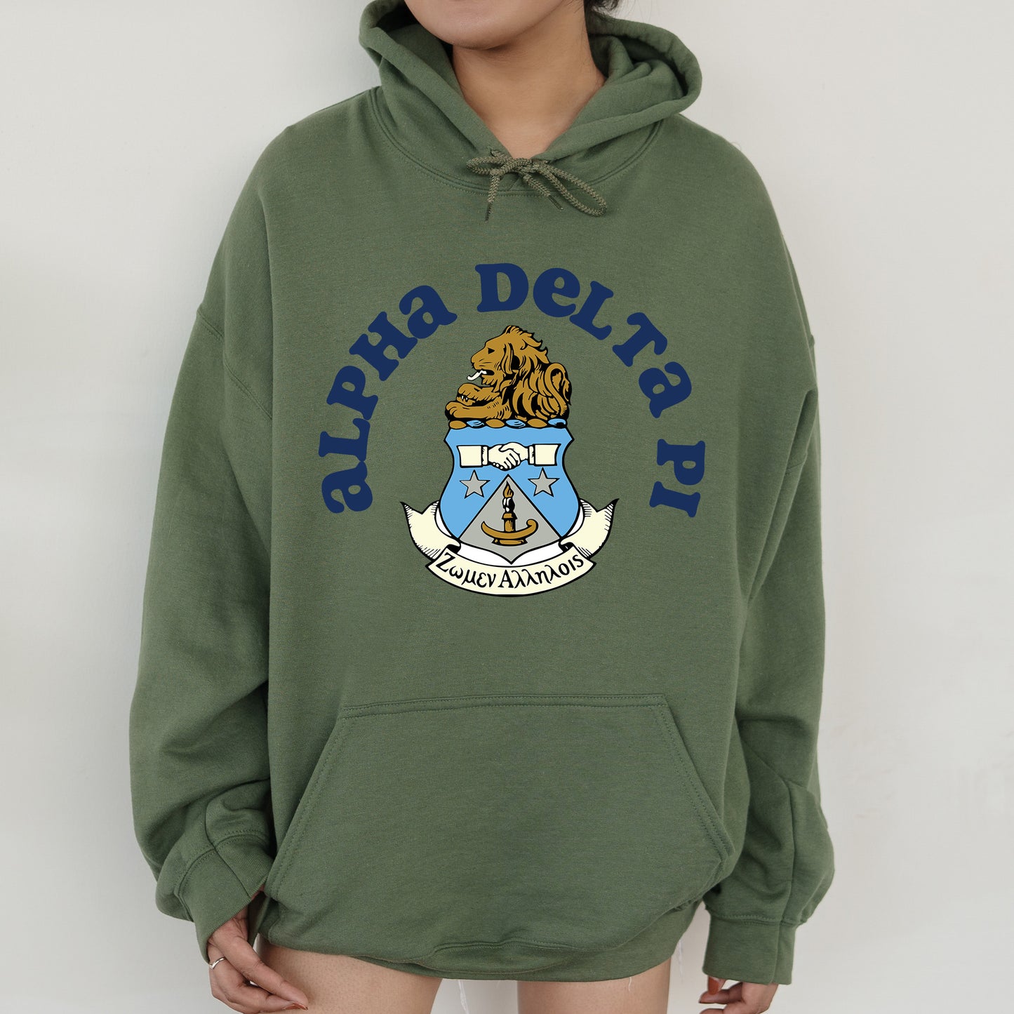 a person wearing a green hoodie with a coat of arms on it
