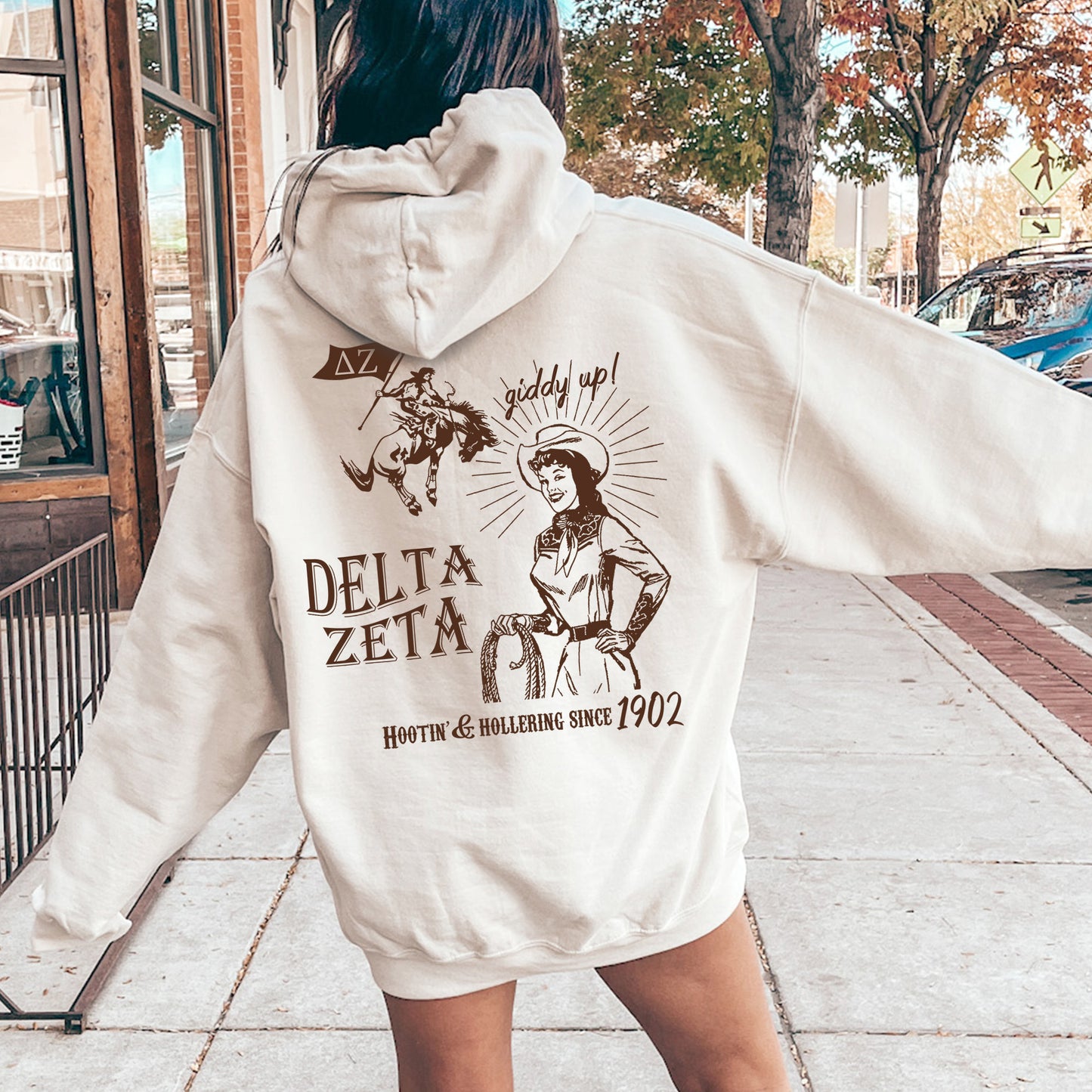 a woman in a white hoodie is walking down the street