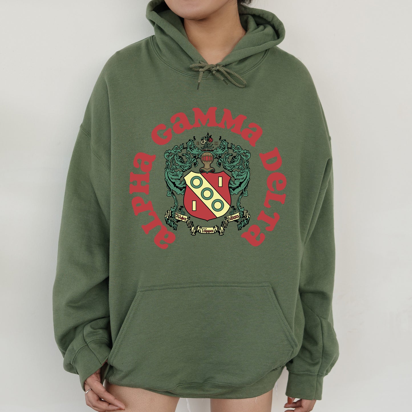 a person wearing a green hoodie with a red and green crest on it