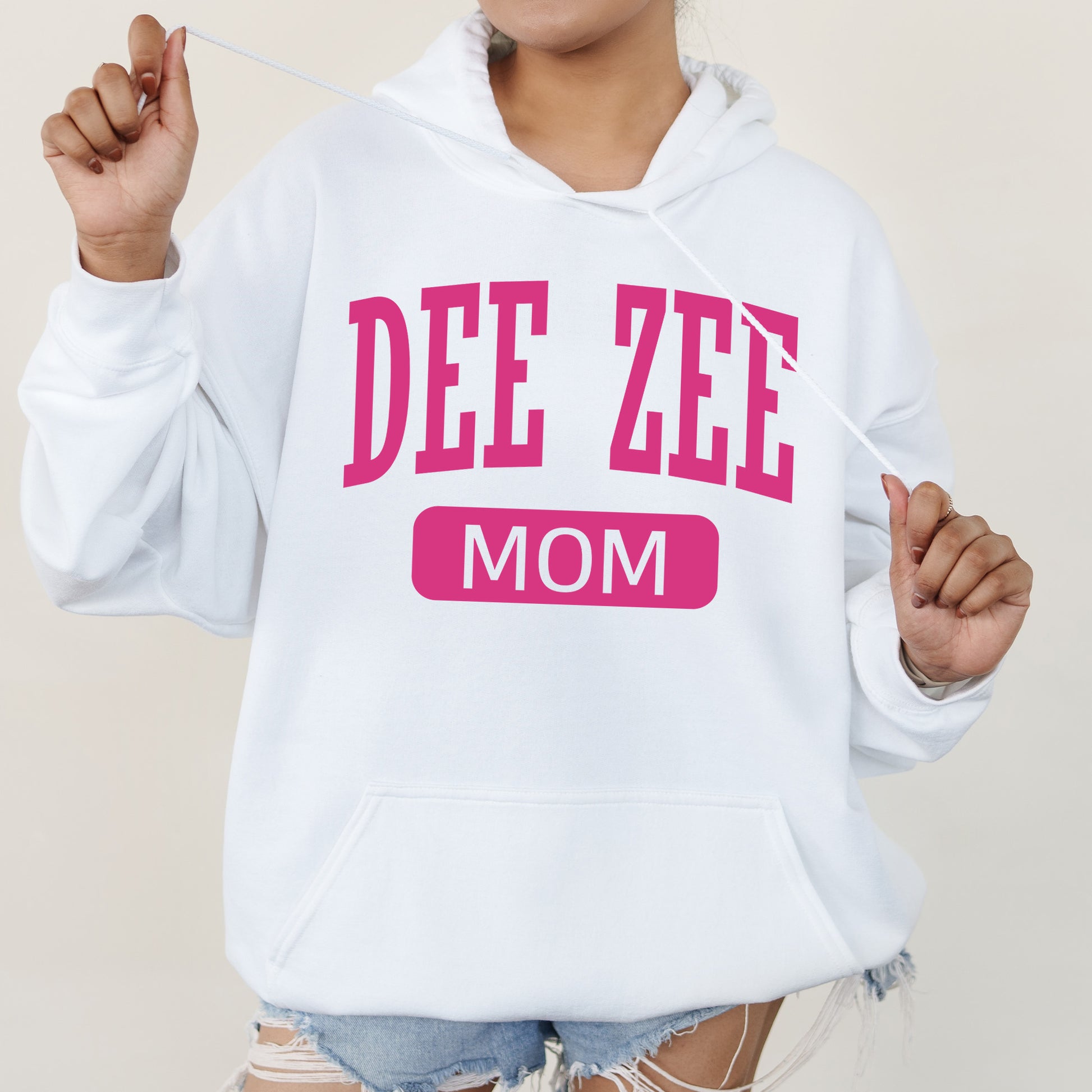 a woman wearing a hoodie that says dee zeee mom