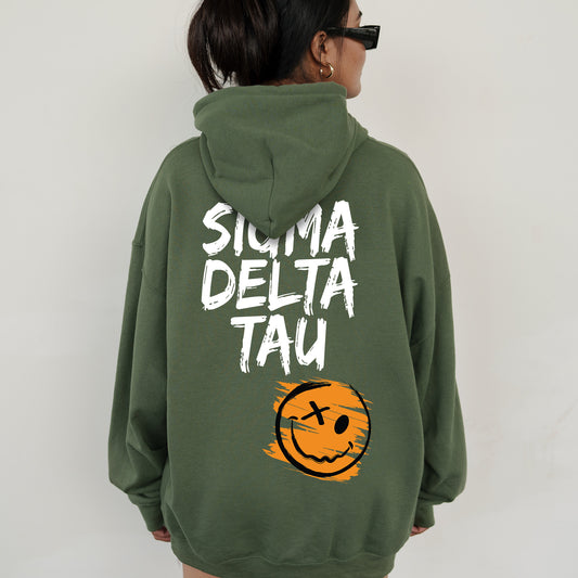 a woman wearing a green sweatshirt with a smiley face on it