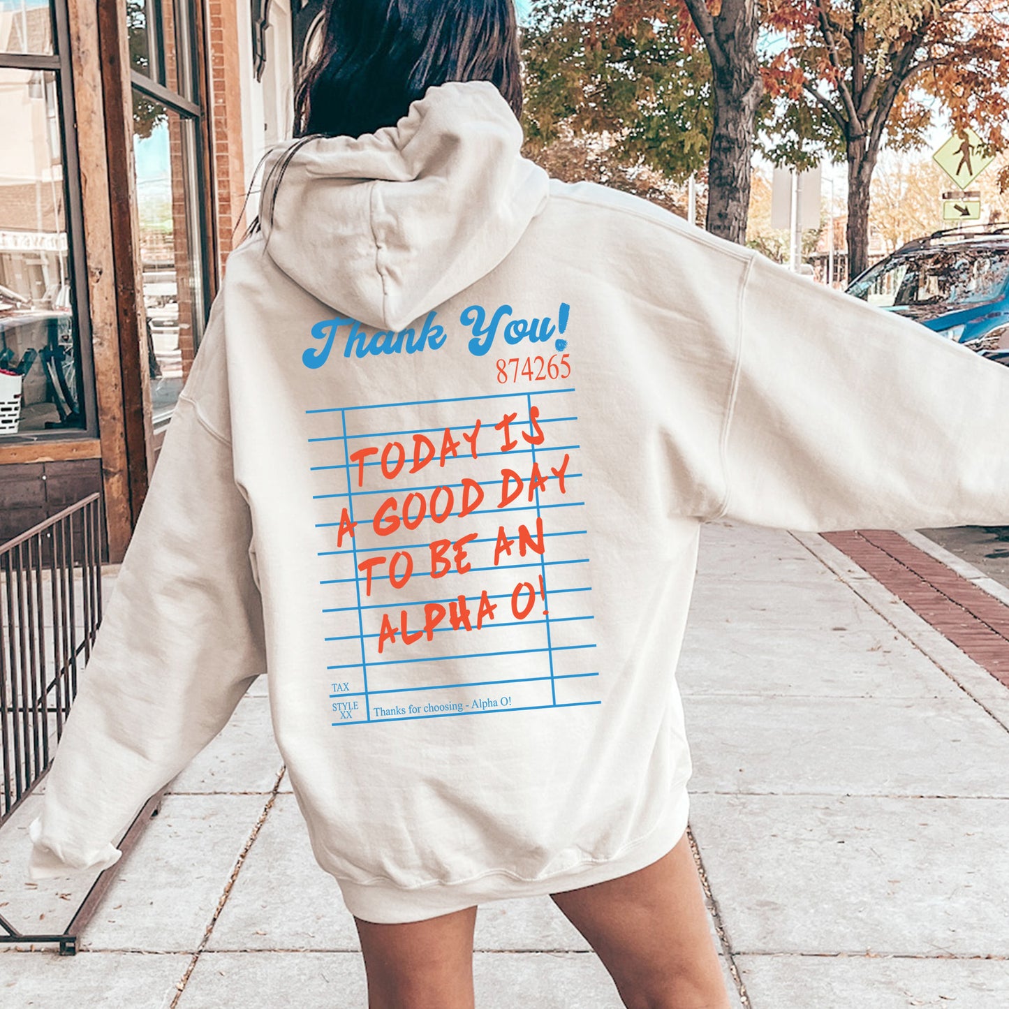 a woman in a white hoodie is walking down the street
