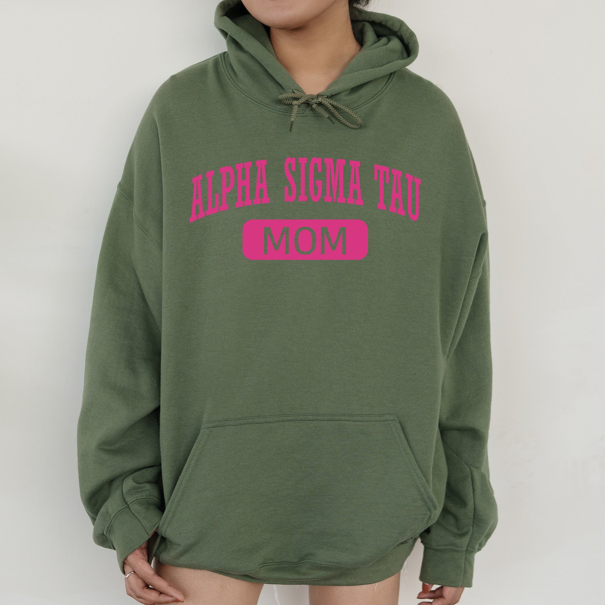 a woman wearing a green hoodie with pink letters on it