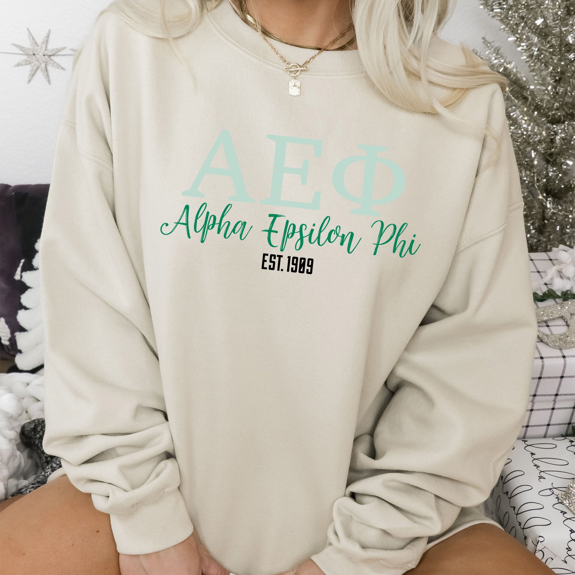 a woman sitting on a bed wearing a sweatshirt