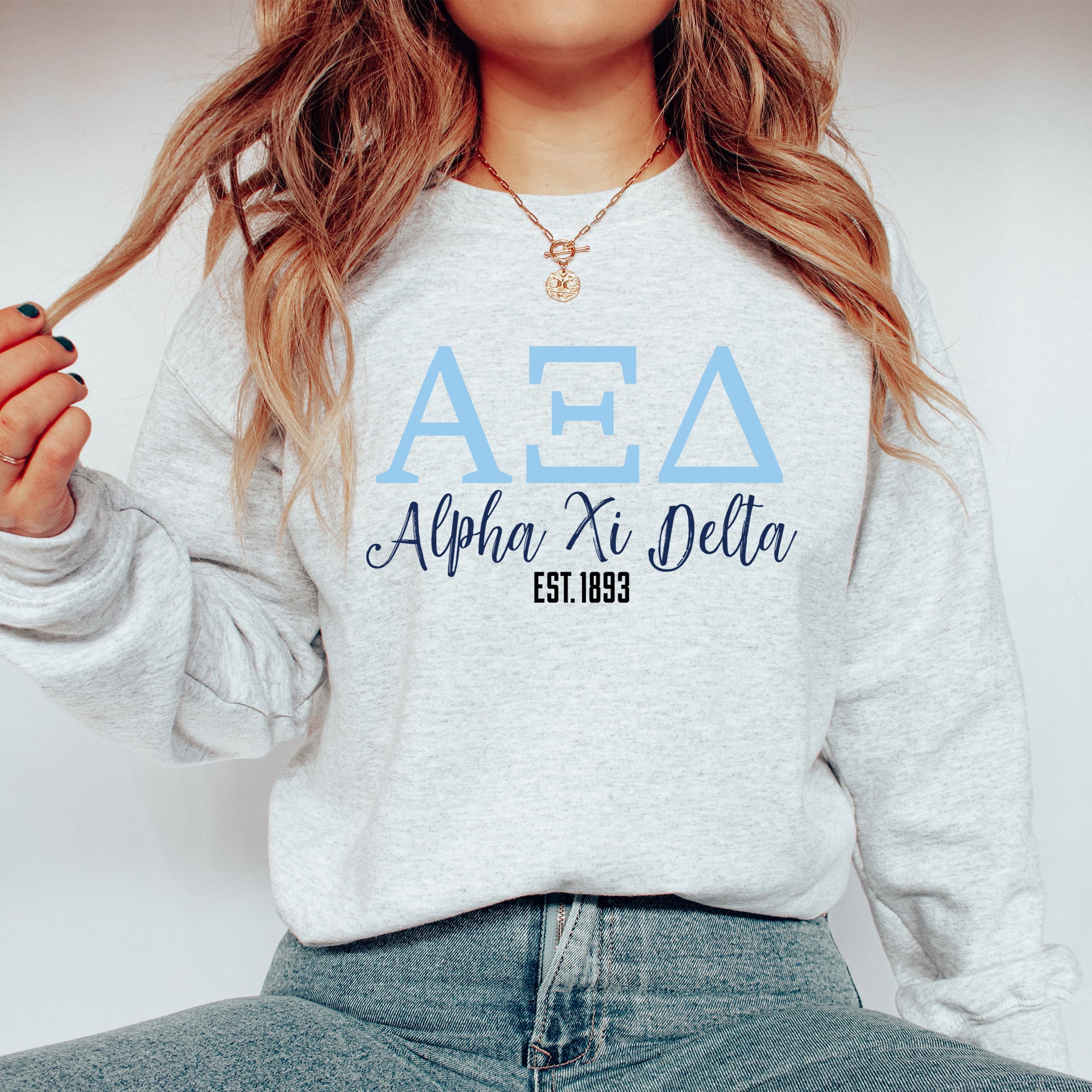 a woman wearing a delta sweatshirt and jeans