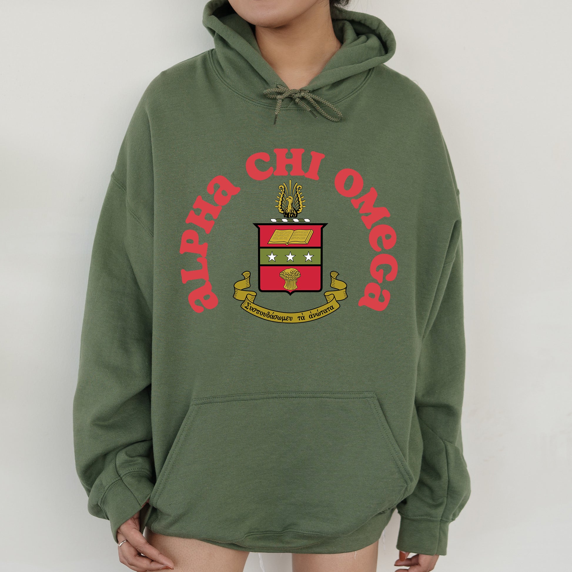 a person wearing a green hoodie with a crest on it