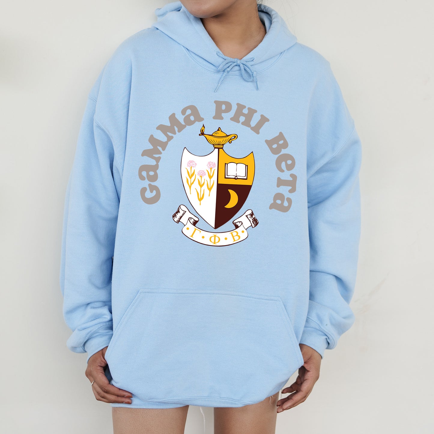 a person wearing a blue hoodie with a crown on it