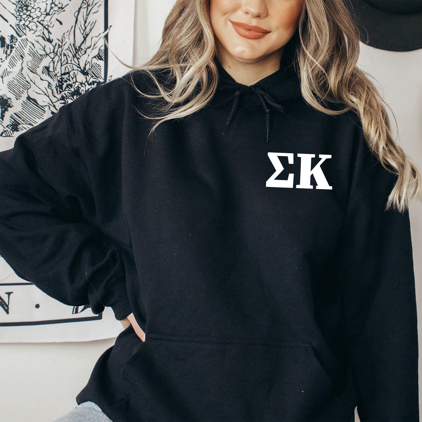 a woman wearing a black hoodie with the letter k on it