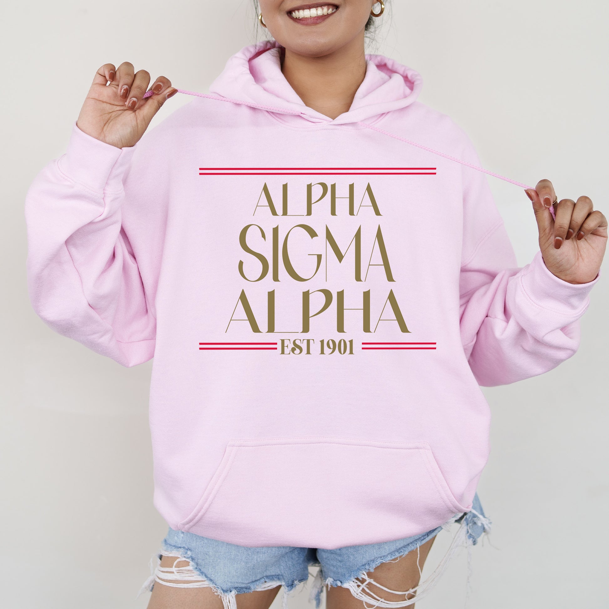 a woman wearing a pink hoodie with the words,'alpha sigm