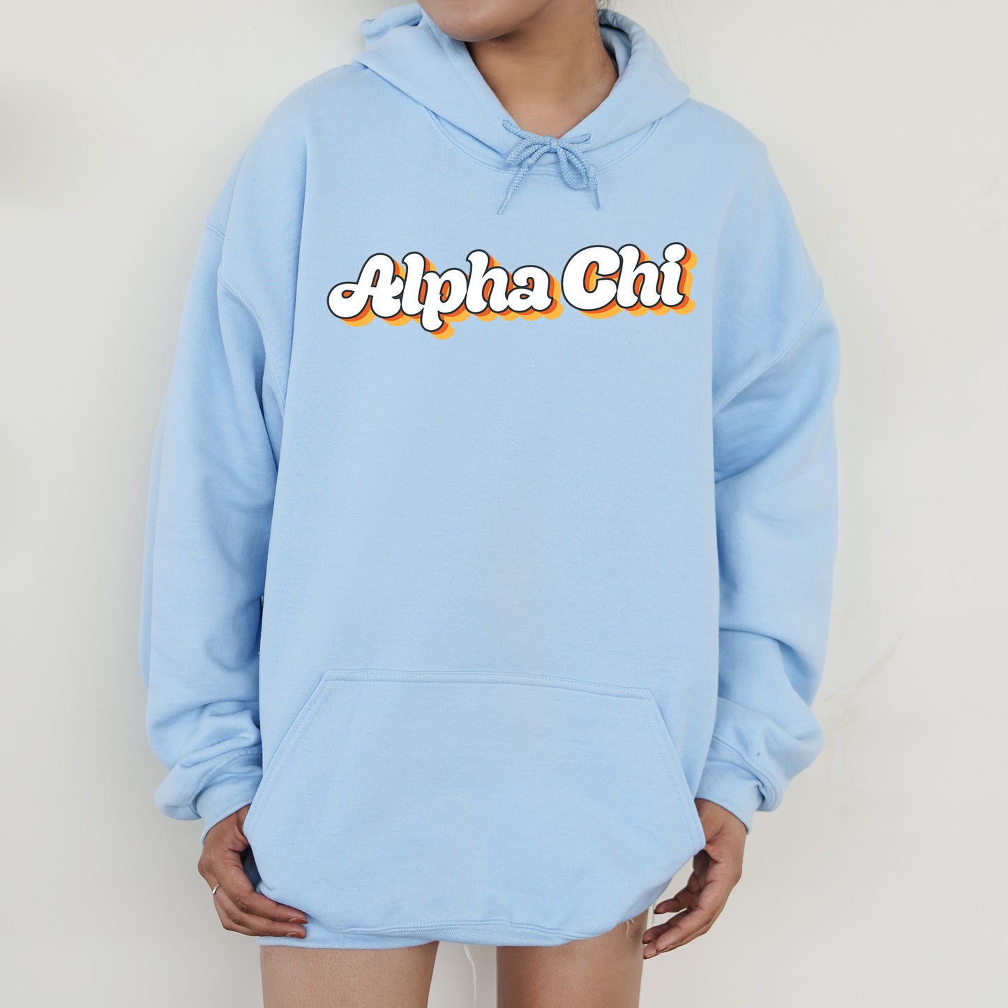 a person wearing a blue hoodie with the word alpha chi on it