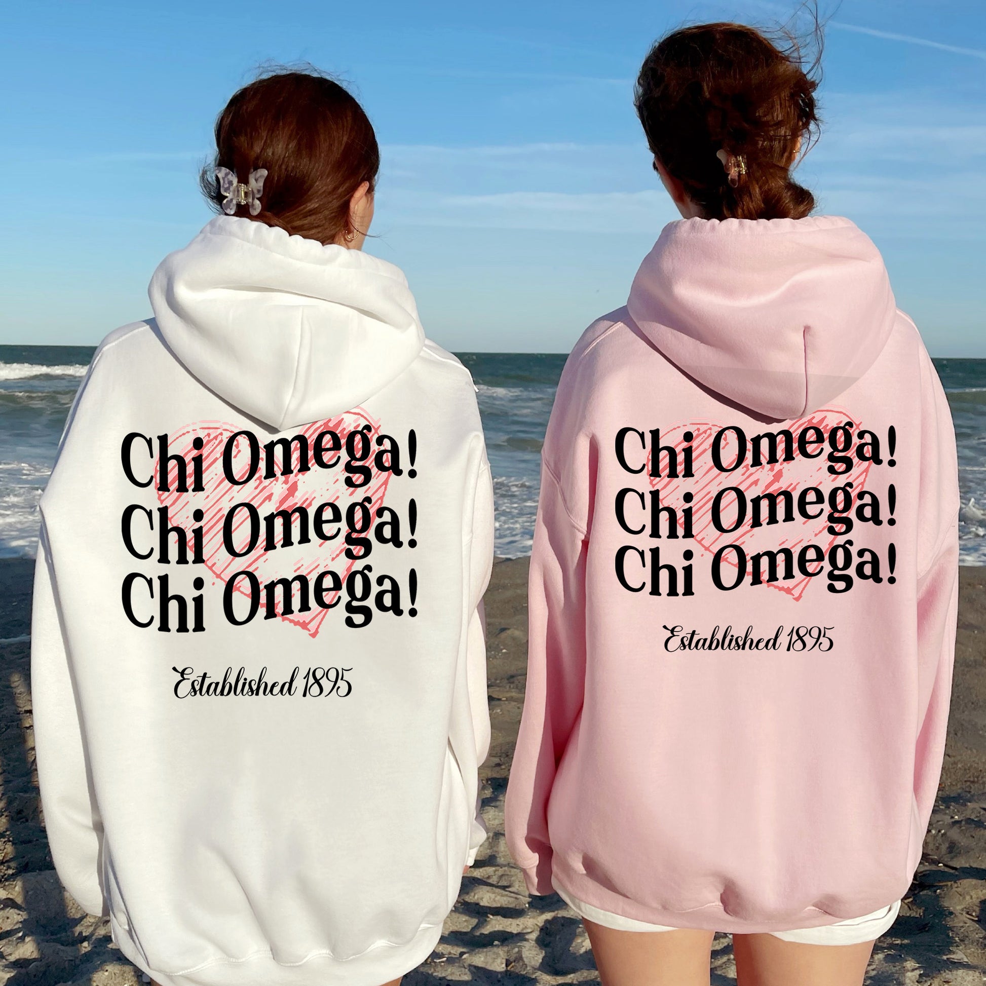 two women in matching sweatshirts standing on the beach