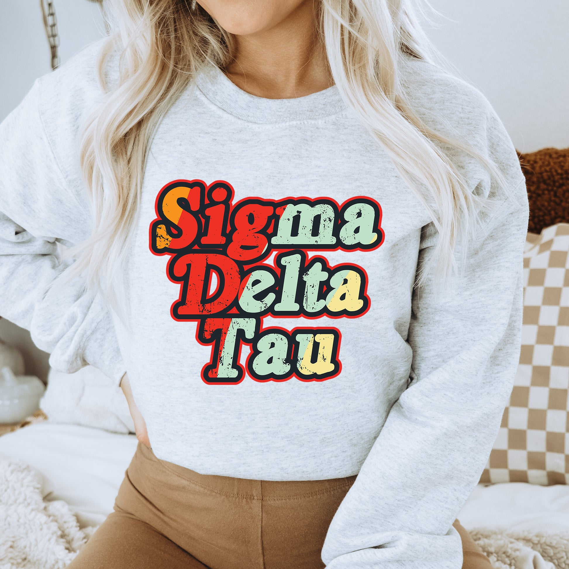 a woman wearing a sweatshirt that says stigma delta tau