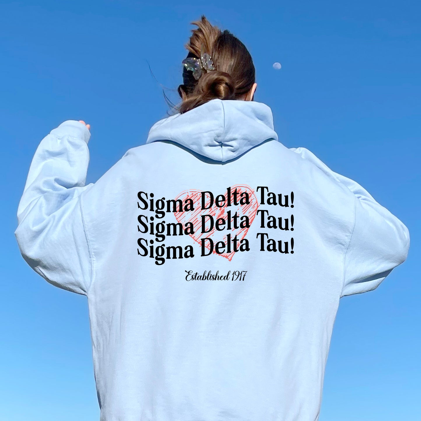 a woman in a white hoodie is flying a kite