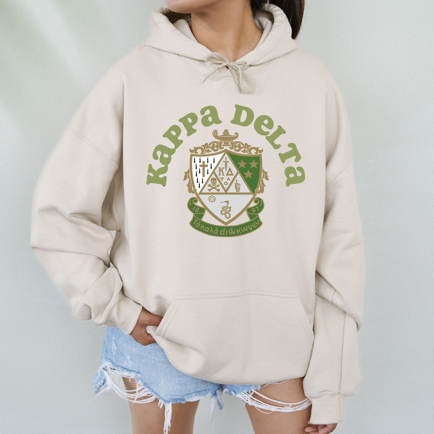 a woman wearing a white hoodie with a green crest on it