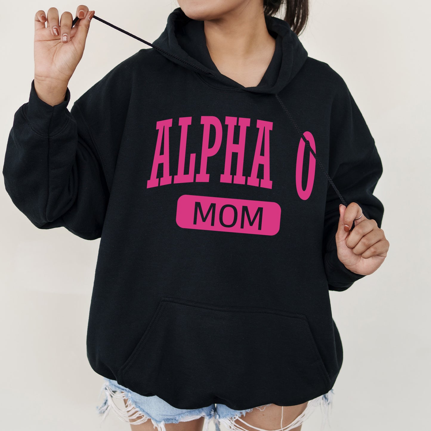 a woman wearing a black hoodie with pink letters on it