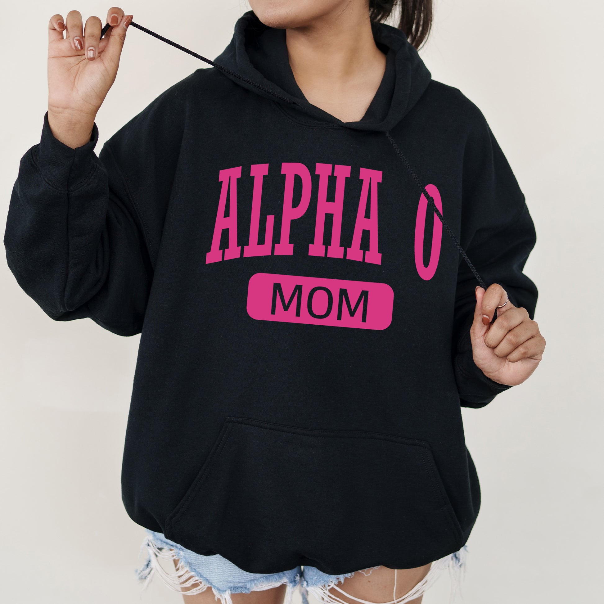 a woman wearing a black hoodie with pink letters on it