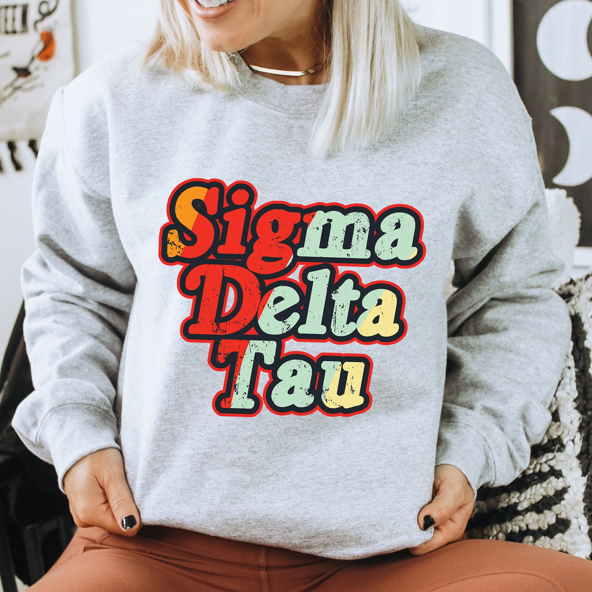 a woman sitting on a chair wearing a grey sweatshirt with the words sing dal dal