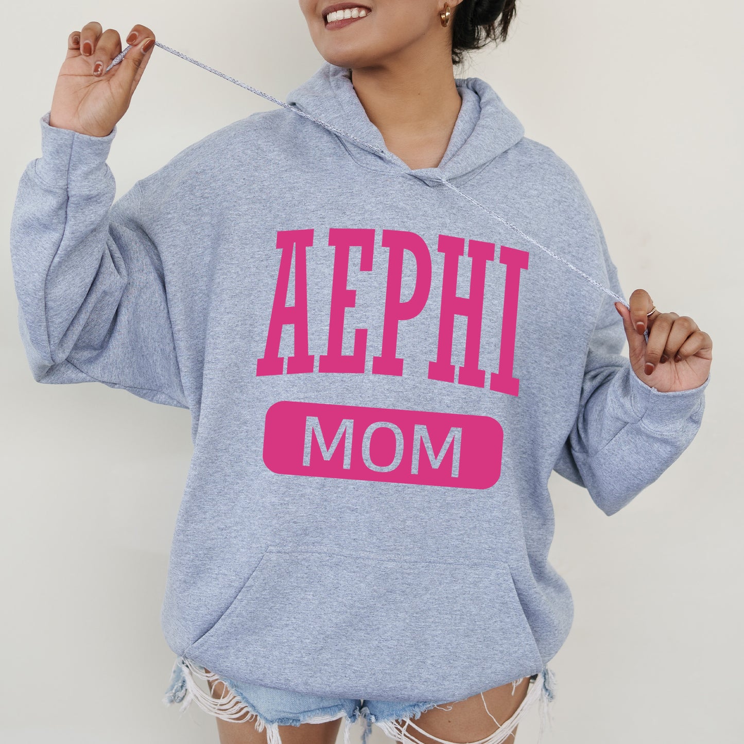 a woman wearing a sweatshirt that says aephh mom