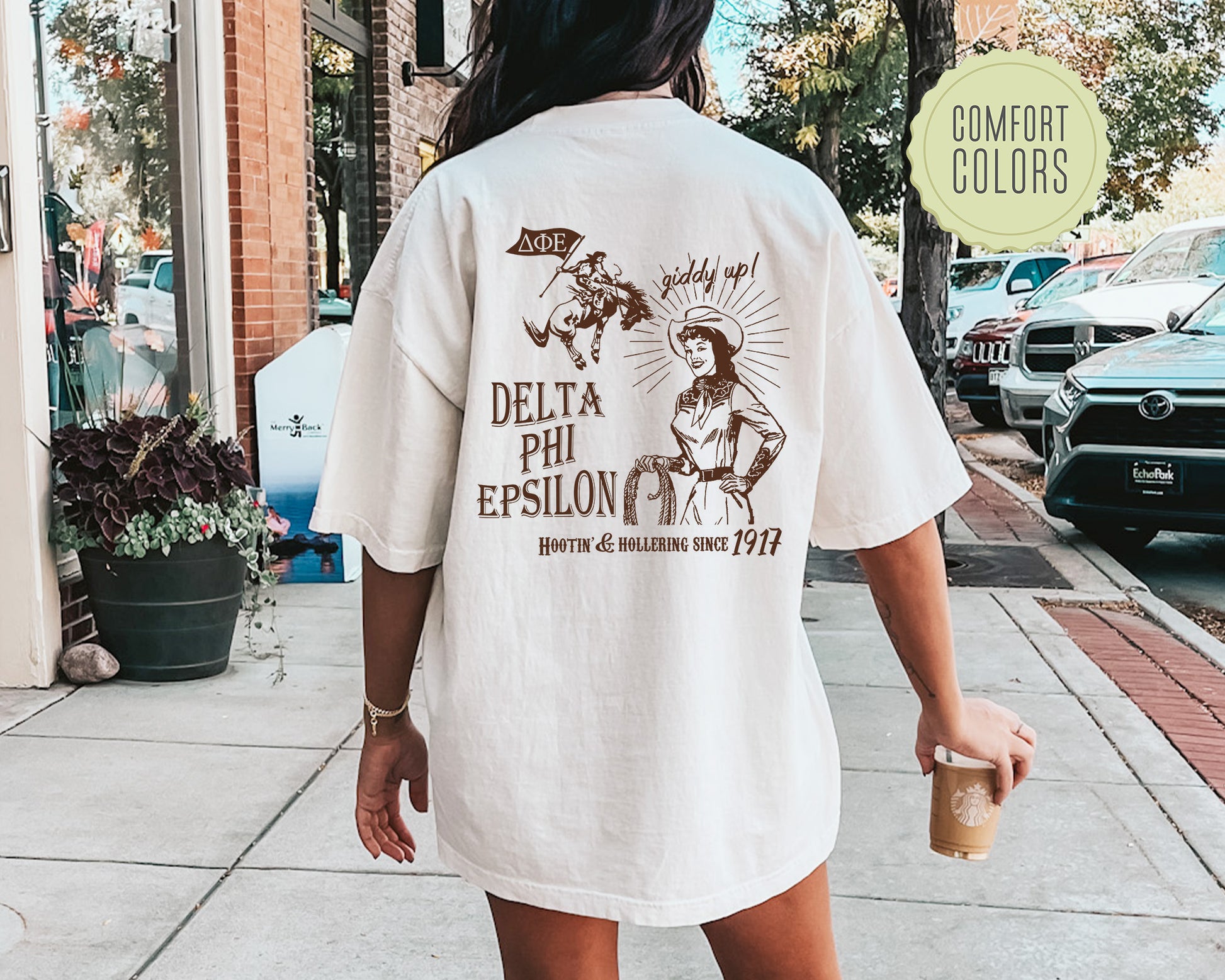 a woman walking down a sidewalk holding a cup of coffee