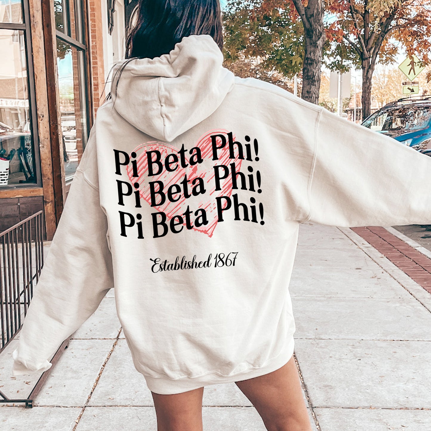 a woman in a white hoodie is walking down the street