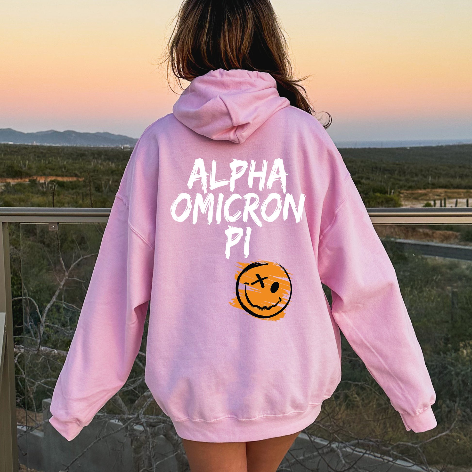 a girl wearing a pink sweatshirt with a smiley face on it