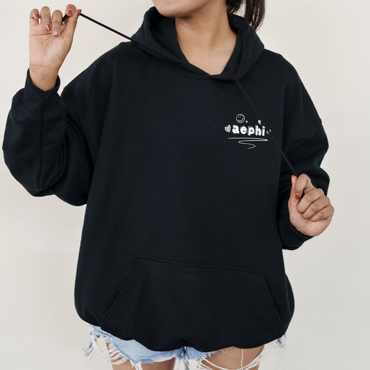 a woman in a black hoodie holding a stick